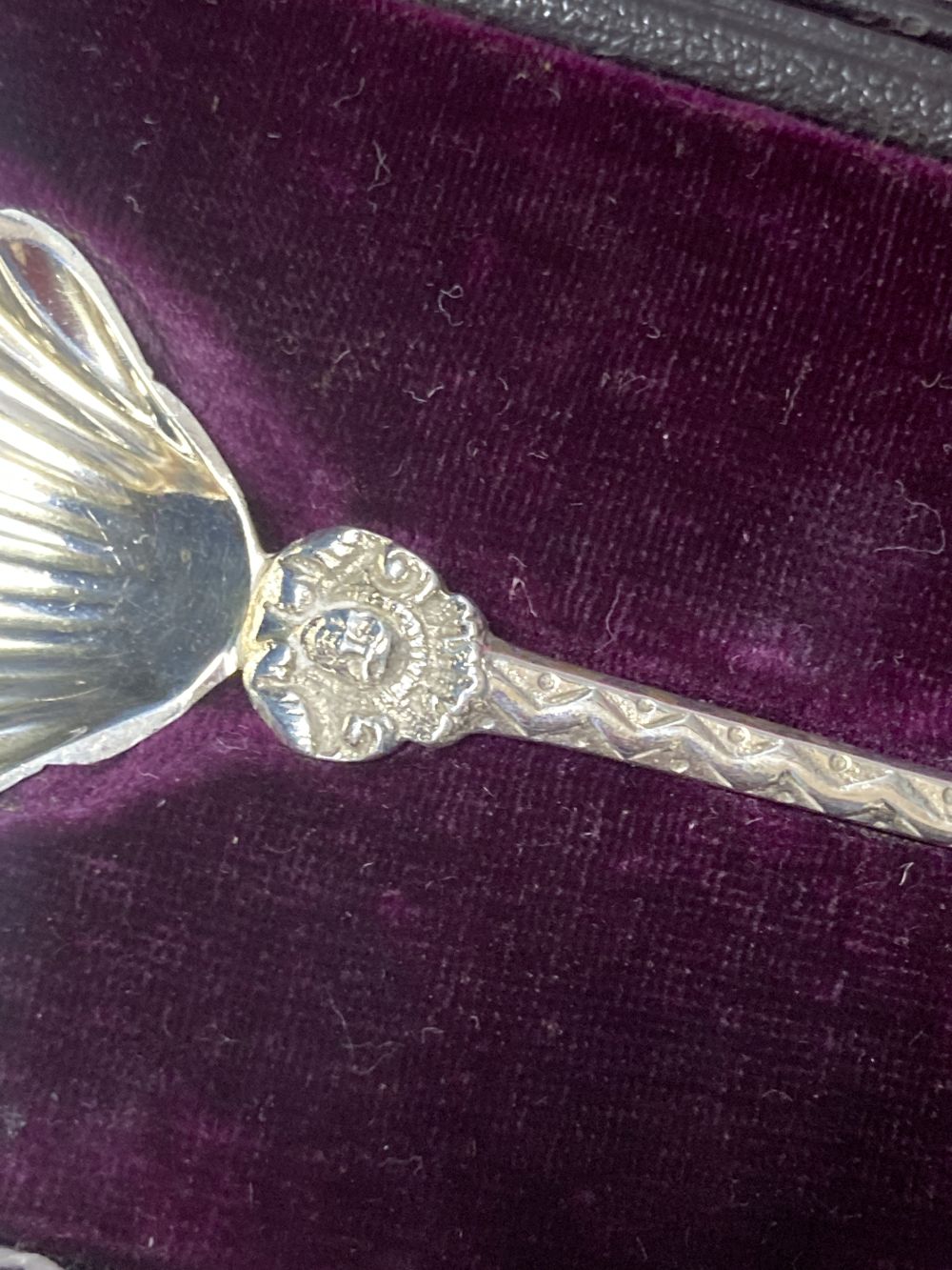 A cased pair of late Victorian silver serving spoons, with shell bowls and figural terminals,